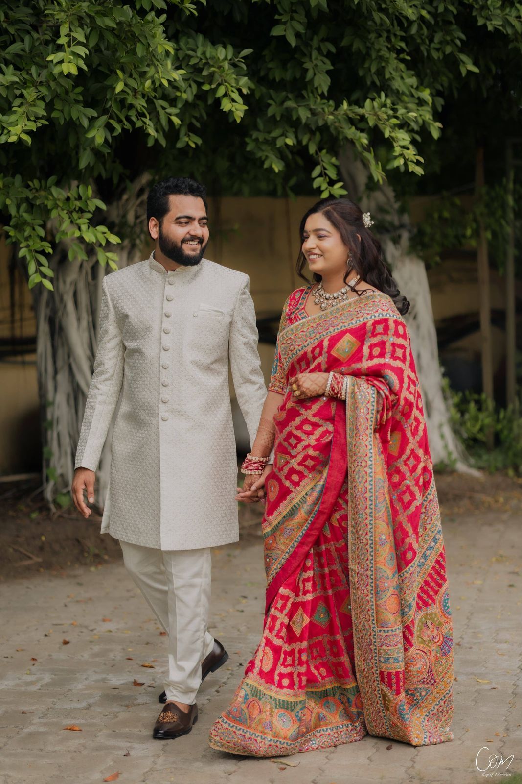 Satyam and Anshi walking hand in hand under the trees